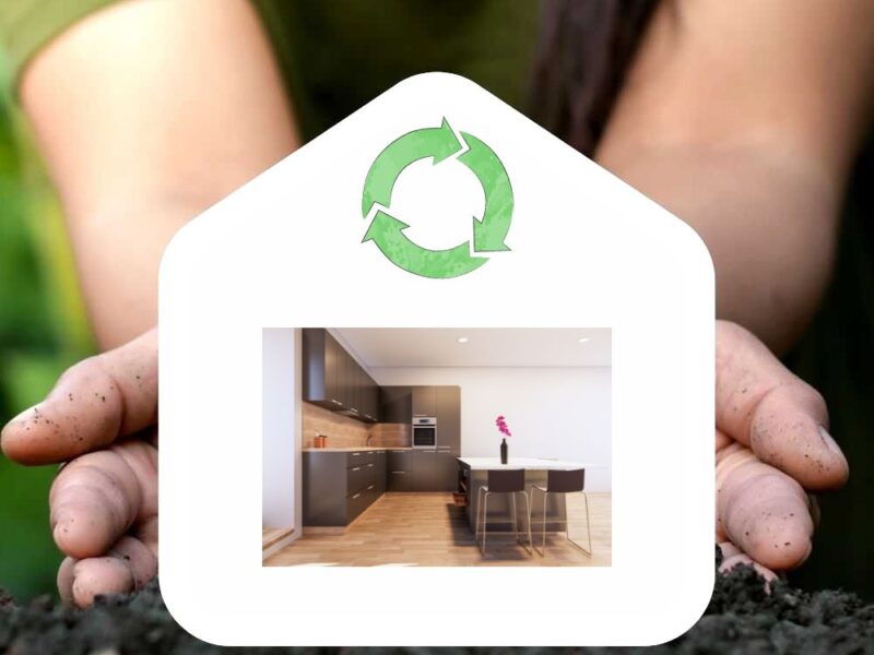 Una cocina ecológica dentro de dibujo de una casa que sostienen las manos de una persona. Es el símbolo de sostenibilidad.